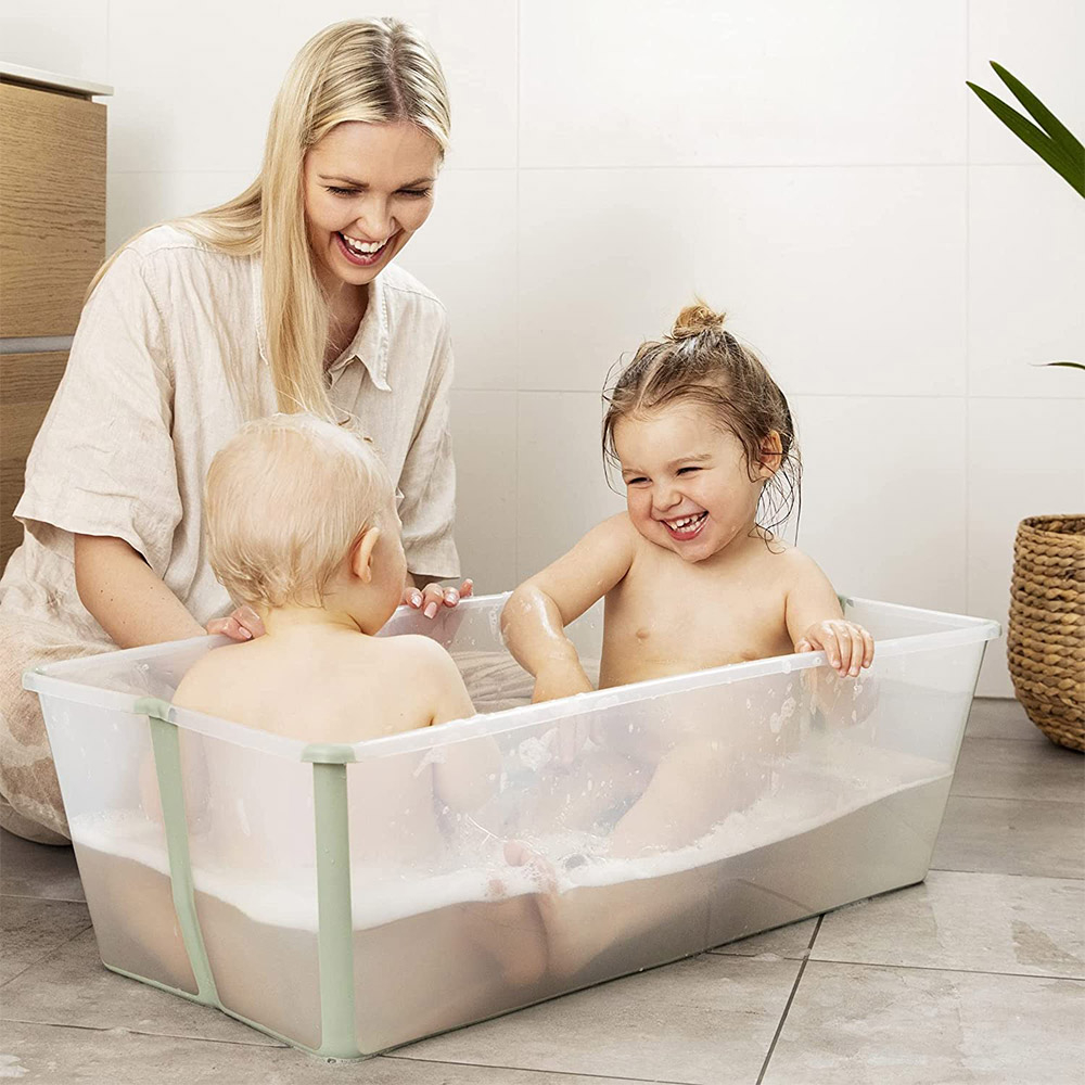 Dos bebés bañandose en una bañera plegable