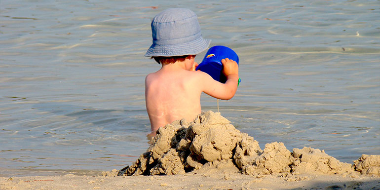 bebé jugando en la playa