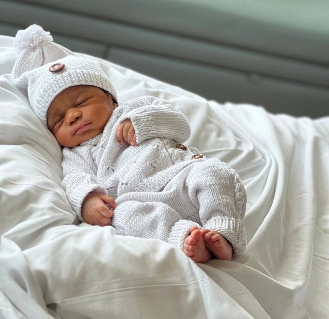 recien nacido con ropita en la cama